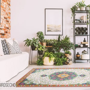 May include: A white and green patterned rug with a floral design. The rug is in a living room with a white couch, brick wall, and plants.