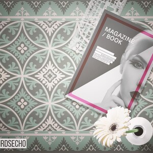 May include: A magazine or book with the text "MAGAZINE/BOOK" on the cover. The cover features a black and white photo of a woman's face. The magazine is lying on a patterned floor with a white flower in a white vase.