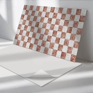 Peut inclure: Une feuille de carrelage en vinyle auto-adhésif avec un motif en damier. Les carreaux sont blancs et d'une couleur brun clair avec un effet marbré.