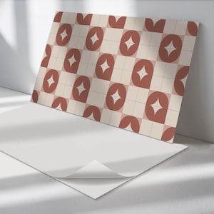 May include: A sheet of peel and stick wallpaper with a geometric pattern. The pattern features a repeating design of red and white shapes on a cream background.