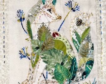 May include: A fabric art piece featuring a fox with a patchwork design. The fox is surrounded by green leaves, blue flowers, and a bee. The artwork is on a cream-colored background with a floral border and stitched details.