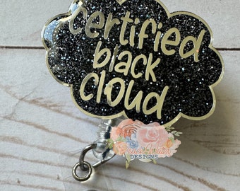 以下が含まれることがあります： 金色の輪郭と「certified black cloud」という文字が書かれた、黒いグリッターの雲の形をしたバッジホルダーです。