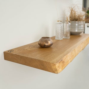 Floating wall shelf made of natural oiled solid oak wood with and without tree edge. Wall shelf in various sizes. Decoration for the living room and kitchen