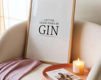 Puede incluir: Un cuadro enmarcado con el texto "LET THE GOOD TIMES BE GIN" en negro. El cuadro está en un marco de madera clara, apoyado en una silla blanca. Una bandeja rosa contiene una vela y una revista. Una manta rosa está sobre la silla.