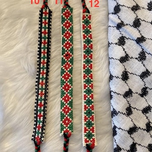 May include: Three friendship bracelets made with red, green, white and black thread. The bracelets are labelled 10, 11 and 12.