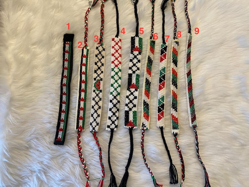 May include: Nine colourful bracelets with white, red, green and black beads. The bracelets are numbered 1 through 9.
