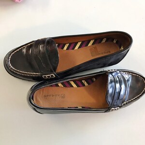 These vintage SPERRY TOP-SiDER pENNY LOAFERS are in EXCELLENT condition 'cause they've NEVER been worn!  They're shiny black patent leather with white stitching and of course, the slot to stick a penny in.  Black lug soles of non-marking rubber.  They're VERY clean with NO wear.  Size 7.5.