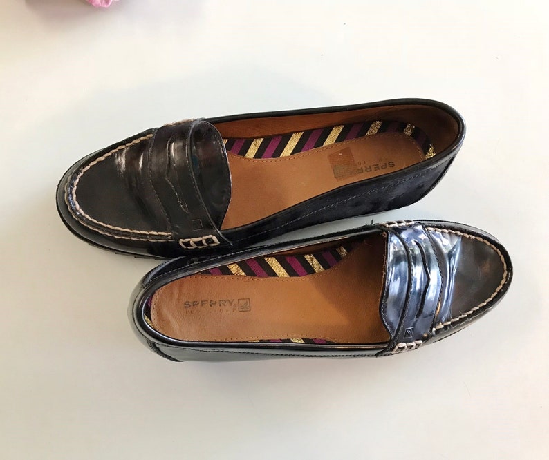 These vintage SPERRY TOP-SiDER pENNY LOAFERS are in EXCELLENT condition 'cause they've NEVER been worn!  They're shiny black patent leather with white stitching and of course, the slot to stick a penny in.  Black lug soles of non-marking rubber.  They're VERY clean with NO wear.  Size 7.5.