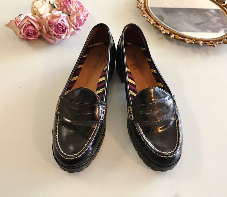 These vintage SPERRY TOP-SiDER PENNY LOAFERS are in GREAT condition 'cause they've never been worn.  Good looking black patent leather with white stitching and lug rubber sole.  Size 7.5. Don't forget to put a penny in the slot!