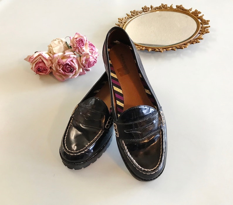These vintage SPERRY TOP-SiDER PENNY LOAFERS are in GREAT condition 'cause they've never been worn.  Good looking black patent leather with white stitching and lug rubber sole.  Size 7.5. Don't forget to put a penny in the slot!