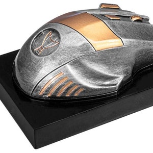 Könnte beinhalten: Silberne und goldfarbene Trophäen-Maus-Figur auf einem schwarzen Sockel. Die Maus hat ein Trophäen-Cup-Design an der Seite und einen goldenen Streifen über der Oberseite.