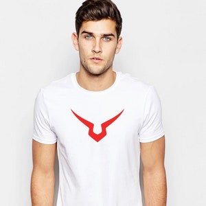 May include: White t-shirt with a red graphic of a stylised V shape.