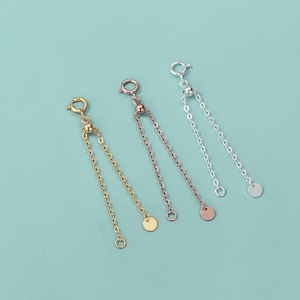 May include: Three gold, silver, and rose gold chain extenders with a small ball and a flat disc at the end. The extenders are used to adjust the length of necklaces or bracelets.