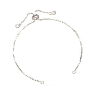 Puede incluir: Un brazalete de cadena de plata con un cierre deslizante y dos pequeñas piedras transparentes.