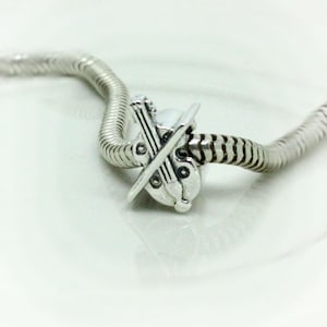Può includere: Un braccialetto con ciondolo in argento con un ciondolo a forma di violino e arco.