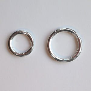 Puede incluir: Dos llaveros de plata, uno más grande que el otro, ambos con un acabado martillado.