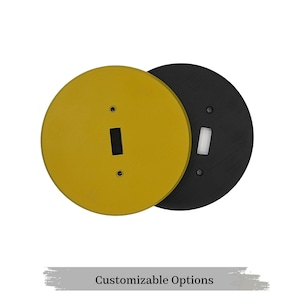 May include: Two round light switch covers, one yellow and one black. The covers are slightly overlapping. 'Customizable Options' is written in grey text below the covers.
