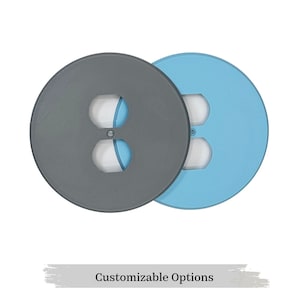 May include: Two round outlet covers, one grey and one light blue, with a double outlet cutout in the centre.