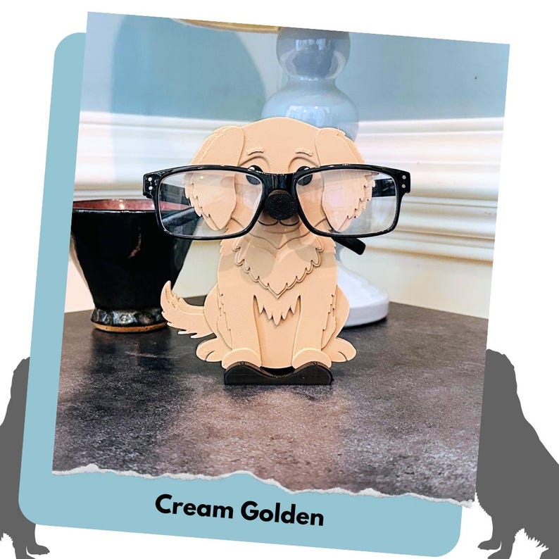 May include: A cream-coloured wooden figurine of a golden retriever wearing black glasses. The figurine is a glasses holder and is sitting on a dark grey surface.