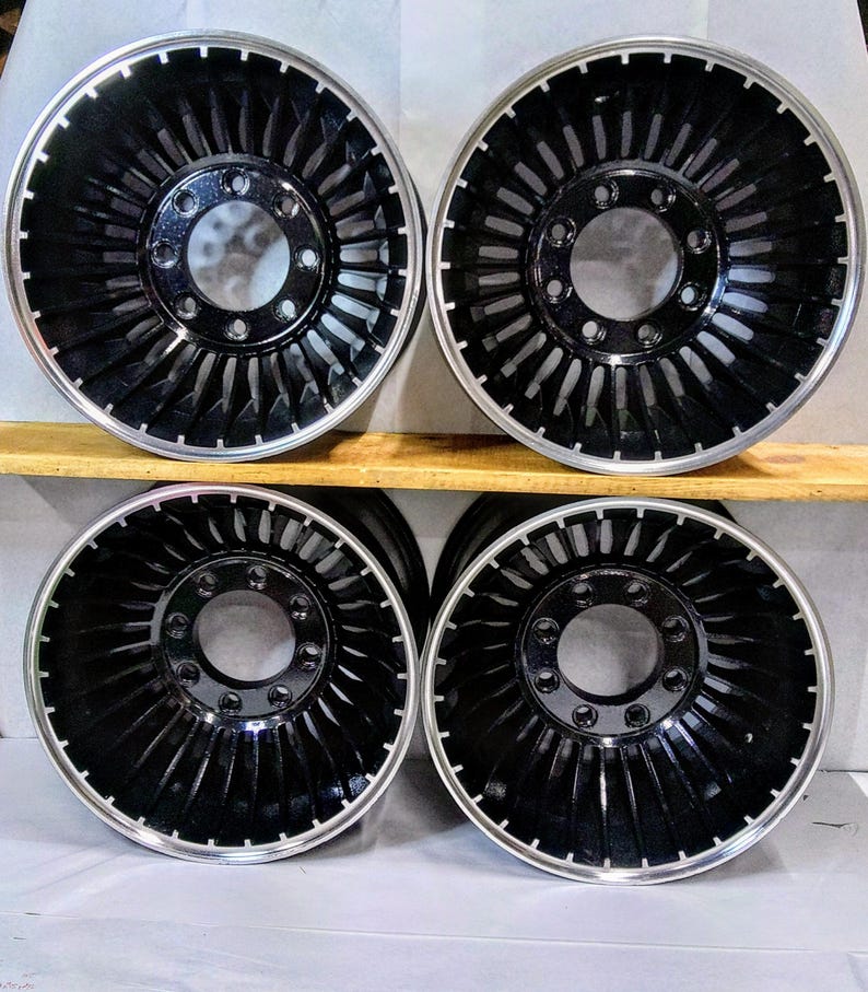 Puede incluir: Cuatro ruedas negras y plateadas de estilo turbina con llanta cromada. Las ruedas tienen un dise&ntilde;o &uacute;nico con una serie de radios que se asemejan a una pala de turbina.