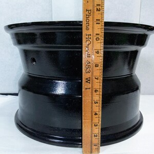 Puede incluir: Una llanta de rueda de metal negro con un di&aacute;metro de 17,8 cm. La llanta tiene un acabado liso y brillante y est&aacute; hecha de metal duradero.