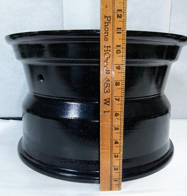 Puede incluir: Una llanta de rueda de metal negro con un di&aacute;metro de 17,8 cm. La llanta tiene un acabado liso y brillante y est&aacute; hecha de metal duradero.