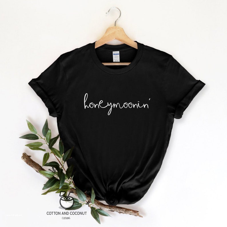 May include: Black t-shirt with the text "honeymoonin'" written in white cursive script.
