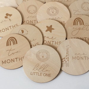 Pu&ograve; includere: Una collezione di dischi di pietre miliari in legno per un bambino. Ogni disco &egrave; rotondo e presenta un design inciso al laser, tra cui animali, arcobaleni e le parole "hello LITTLE ONE" e i mesi da uno a dodici.
