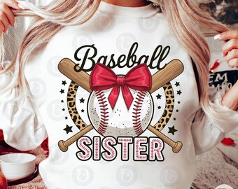 Peut inclure: Sweat-shirt blanc avec un motif sur le thème du baseball. Le motif comprend une balle de baseball avec un nœud rouge, des battes croisées et les mots "Baseball" et "SISTER". Des étoiles et des imprimés léopard complètent le design.