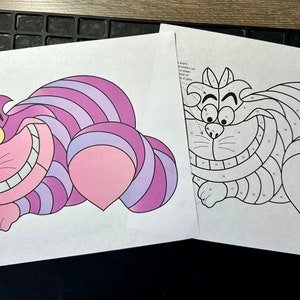 Peut inclure: Une page à colorier par numéros représentant un chat du Cheshire de dessin animé d'Alice au pays des merveilles. Le chat est allongé, les pattes tendues, et arbore un large sourire. La page à colorier est divisée en sections numérotées, chaque section correspondant à une couleur différente.