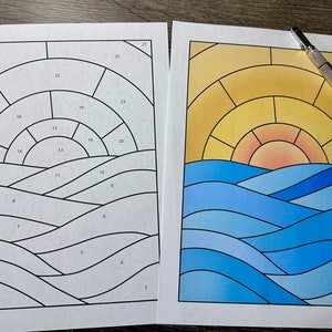 May include: A black and white numbered template for a stained glass project depicting a sunset over the ocean. The finished project shows a yellow sun with orange and red hues over blue and light blue waves.