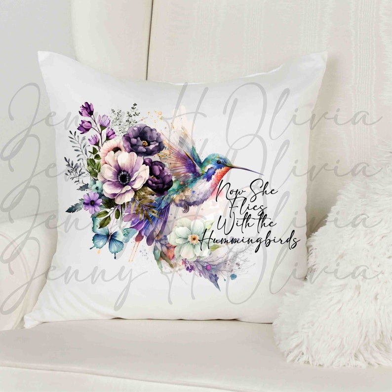 May include: White throw pillow with a watercolor design of a hummingbird flying with flowers and the text "Now She Flies With the Hummingbirds".