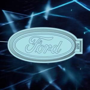 以下が含まれることがあります： 水色のフォードのロゴ。筆記体の「Ford」の文字が楕円形のフレーム内に配置されています。ロゴは銀色の輪郭で、明るい青色のストリークが入った濃い青色の背景に配置されています。