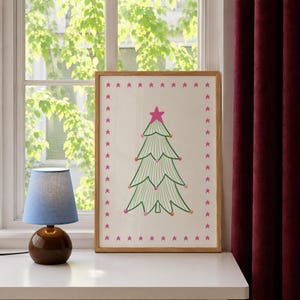 Puede incluir: Una l&aacute;mina enmarcada que muestra un &aacute;rbol de Navidad verde estilizado con l&iacute;neas onduladas, decorado con peque&ntilde;os adornos coloridos y una estrella rosa brillante en la punta, rodeado por un borde de estrellas rosas sobre fondo blanco.