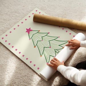 Puede incluir: Un p&oacute;ster cuadrado que presenta un &aacute;rbol de Navidad verde estilizado con l&iacute;neas finas, rematado con una estrella rosa y decorado con peque&ntilde;os adornos circulares rosas y naranjas. El borde tiene un patr&oacute;n de peque&ntilde;as estrellas rosas sobre fondo crema.