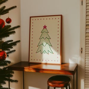 Puede incluir: Una l&aacute;mina de arte rectangular enmarcada con fondo crema, un &aacute;rbol de Navidad central dibujado con l&iacute;neas verdes, coronado por una estrella rosa y decorado con peque&ntilde;os puntos rosas, rodeado por un borde de estrellas rosas.