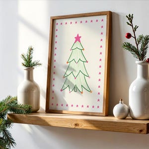 Puede incluir: Una l&aacute;mina enmarcada que muestra un &aacute;rbol de Navidad de l&iacute;neas verdes con una estrella rosa en la punta y peque&ntilde;os adornos coloridos, rodeado por un borde de estrellas rosas. La l&aacute;mina est&aacute; en un marco de madera clara.