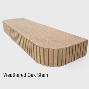 Może przedstawiać: Jasnobrązowa, prostokątna p&oacute;łka wisząca z wykończeniem z postarzanego dębu. Prz&oacute;d i boki mają pionowe rowki. Tekst "Weathered Oak Stain" jest wyświetlany na dole. P&oacute;łka przeznaczona jest do montażu na ścianie.