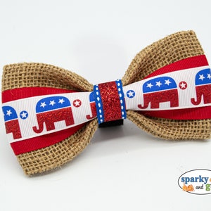 May include: A red, white, and blue bow tie with a burlap base and a ribbon featuring a repeating pattern of red, white, and blue elephants with stars.