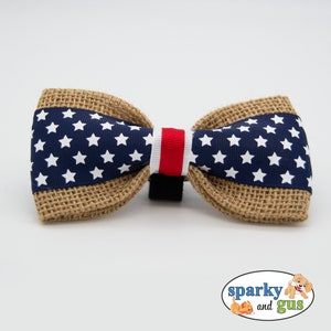 May include: A brown burlap bow tie with a blue and white star pattern and a red and white stripe in the center.