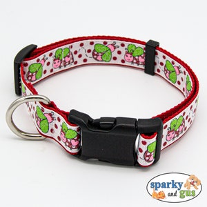May include: Red and white dog collar with a ladybug pattern and red polka dots. The collar has a black plastic buckle.