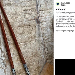 K&ouml;nnte beinhalten: Ein Paar lange, schlanke Essst&auml;bchen mit einem K&ouml;rper aus rotbraunem Holz und einem dekorativen Griffbereich, der mit einem Mosaik aus kleinen, wei&szlig;en und grauen rechteckigen St&uuml;cken eingelegt ist. Die St&auml;bchen liegen diagonal.