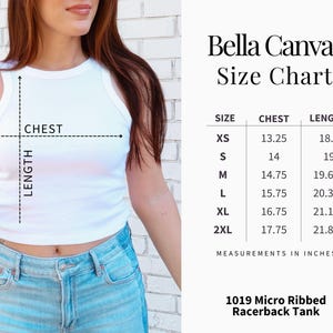 Op de afbeelding: Witte geribbelde racerback tanktop met een maattabel van Bella Canvas. De tabel toont borst- en lengtematen in inches voor maten XS tot 2XL. De tanktop is model 1019.