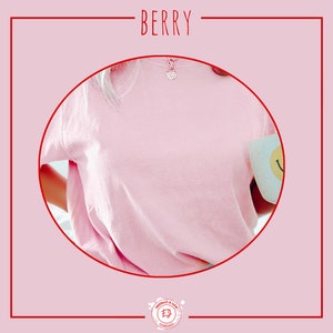 May include: A pink t-shirt with a silver necklace and a white mug with a smiley face design. The t-shirt is made of a soft, comfortable fabric.