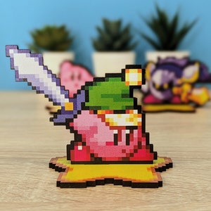 May include: A pink and green pixelated character with a sword, wearing a green hat, standing on a yellow platform. The character is a video game character.