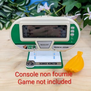 May include: A white ceramic mug with a black handle and the text "But First, Coffee" in a handwritten style. The mug is on a white surface. The mug is likely for hot beverages.