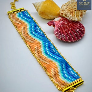 Puede incluir: Pulsera de cuentas con un patrón de olas azules y naranjas. La pulsera tiene un cierre dorado y se muestra sobre una superficie blanca con conchas marinas.