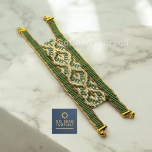 May include: A green and white beaded bracelet with a geometric pattern. The bracelet has gold-colored clasps and is made with small seed beads. The bracelet is on a white marble surface. The text "GO BEAD YOURSELF" is visible in the image.
