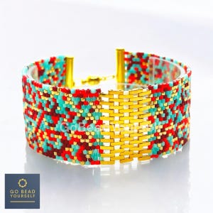 Puede incluir: Una pulsera ancha de cuentas con cierre y detalles dorados. La pulsera presenta un patrón de cuentas rojas, turquesas y doradas. El centro de la pulsera es un diseño de metal dorado. La pulsera está etiquetada "Go Bead Yourself".