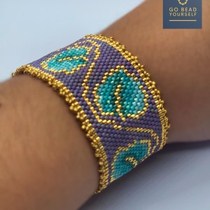 May include: A purple and turquoise beaded bracelet with gold accents. The bracelet is made with small beads and has a geometric pattern. The bracelet is on a person's wrist.